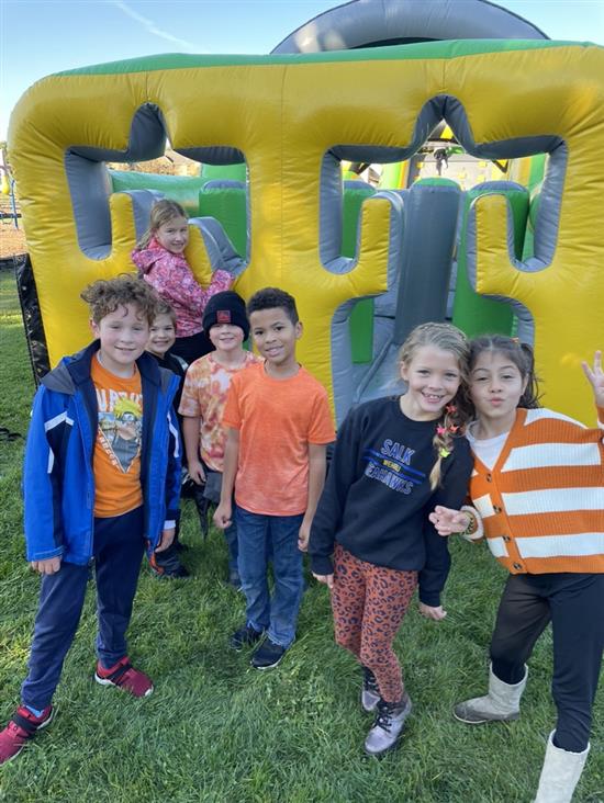 students in front of a bounce house